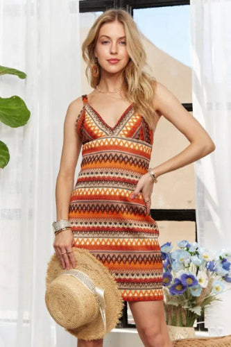 Model wearing contrast striped V-neck mini dress with bold pattern and sleeveless cut
