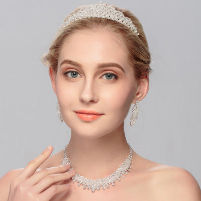 Silver bridal crown and chain jewelry set on white background with velvet pouch – wedding accessories for brides