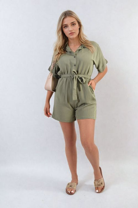 Woman wearing a buttoned tie waist romper in vibrant colour on a sunny day