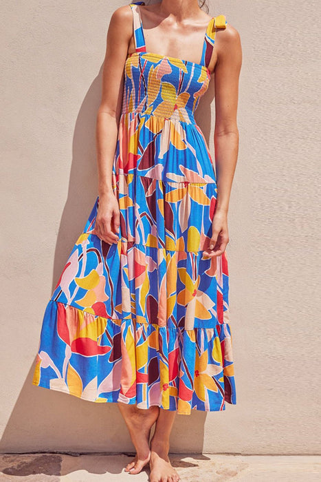 Woman wearing a sleeveless multicolored tiered maxi dress with a square neckline