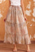 Woman wearing a floral boho maxi skirt with button front and side slit