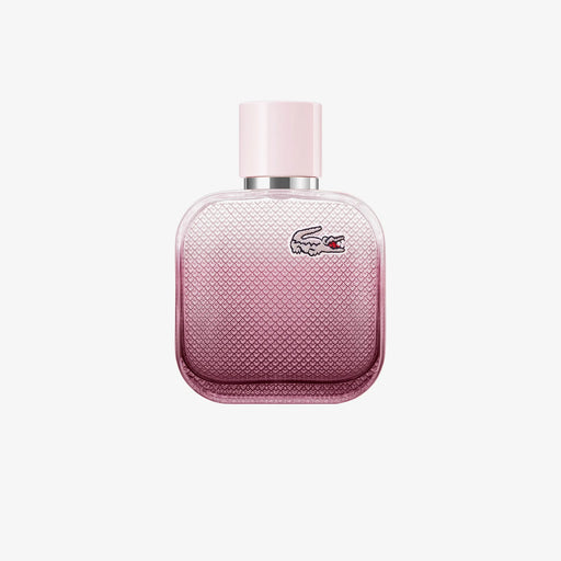 Bottle of L.12.12 Rose Eau Intense perfume with floral elements like rose, iris, cotton flower, and cedarwood in the background