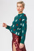 Green cashmere and banana blend Christmas jumper with festive design.