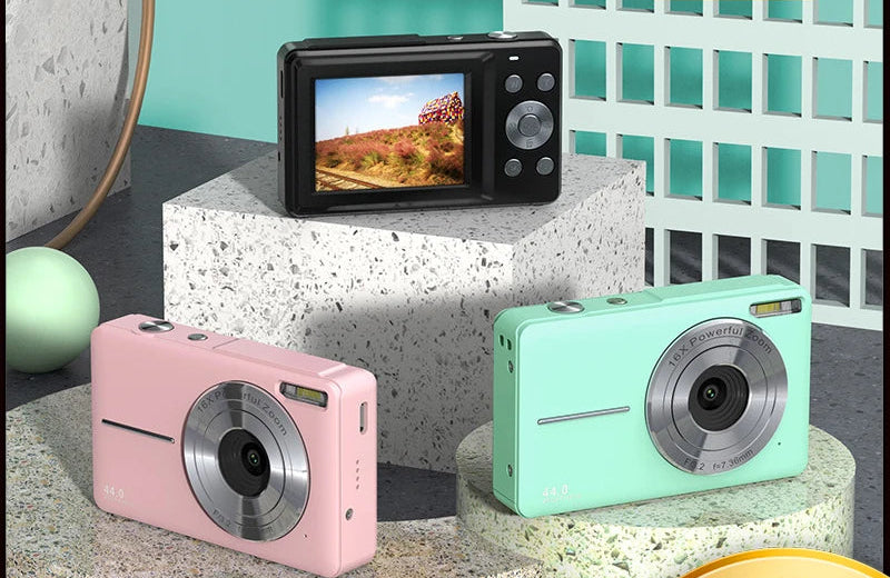 Compact digital camera with 2.5-inch HD screen, 44MP photo resolution, 1080P video recording, and face detection, placed on a desk with travel accessories


