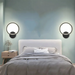 Modern LED wall light with die-cast aluminum finish, mounted in a bedroom with adjustable brightness and color settings