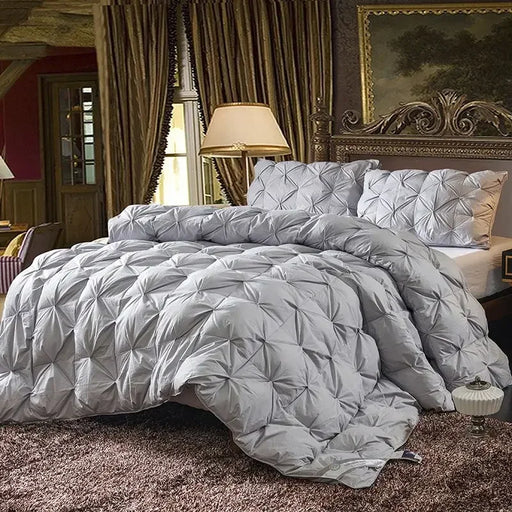 Goose down quilt with 100% cotton cover, quilted stitching, and corner straps for all-season comfort.