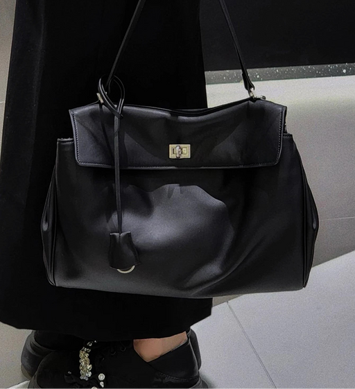 Women’s vegan leather shoulder bag with lock flap closure and soft structure