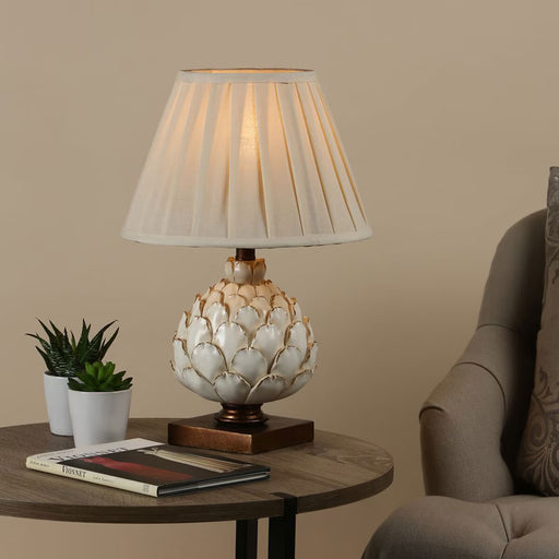 Layer table lamp with antique cream artichoke-inspired base, mottled gold wooden plinth, and pleated ecru shade

