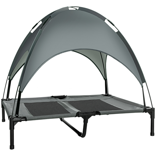 Small to medium dog relaxing on an elevated grey pet lounger with canopy, outdoors on grass

