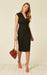 Model wearing a black wrap dress with a V-neck and adjustable tie waist