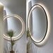 Modern USB-powered LED ring wall lamp mounted on a white interior wall, emitting soft ambient light for bedrooms and living spaces