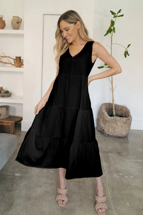 Model wearing sleeveless tiered V-neck dress with a flowy silhouette