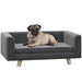 Elevated grey dog bed with wooden legs, orthopedic cushion, and wraparound armrests for small to medium dogs