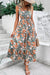 Woman wearing a floral V neck sleeveless dress with a tie waist and tiered hem – perfect for summer.