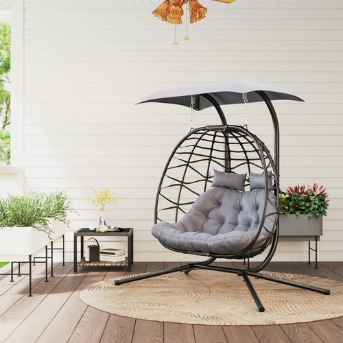 Double rattan swing chair with canopy, cushions, and steel frame for outdoor garden or patio use

