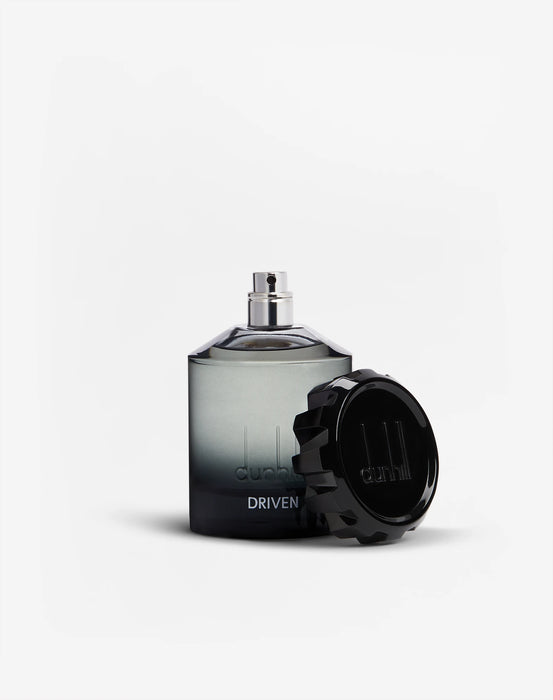 100ml bottle of Driven Eau de Parfum for men surrounded by red apple, cardamom pods, cedarwood and amber elements

