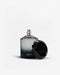 100ml bottle of Driven Eau de Parfum for men surrounded by red apple, cardamom pods, cedarwood and amber elements


